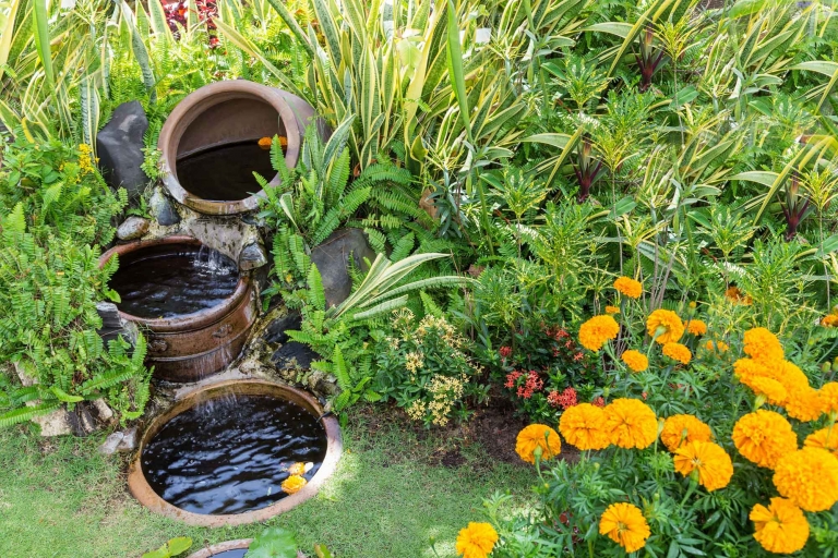 Kaskadenbrunnen mit rustikalen Blumentöpfen in einer schönen Gartenanlage