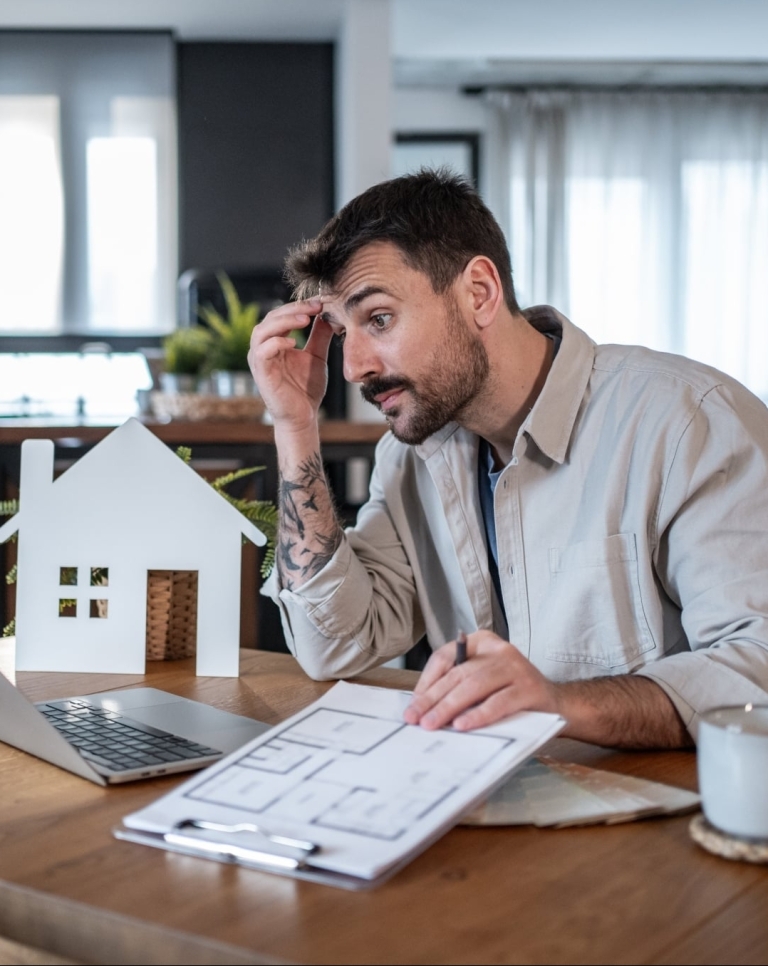 Architect feeling stressed while working at home on housing project