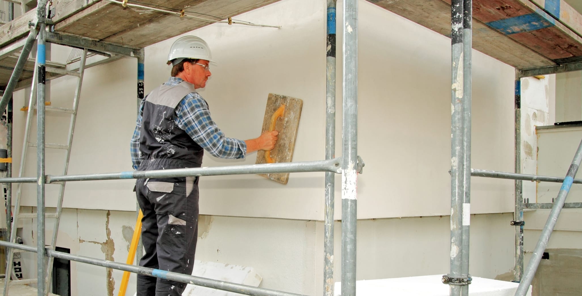 Wärmedämmung, Hausisolierung, Handwerker mit Glättbrett